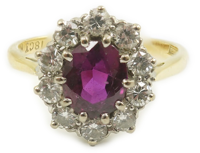 An 18ct gold and platinum, ruby and diamond set oval cluster ring